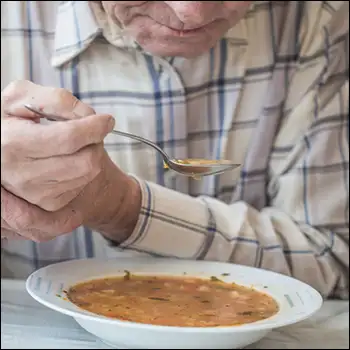 parkinson man holding spoon